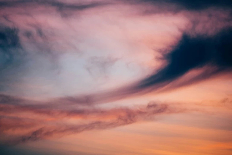 some clouds are in the sky at sunset