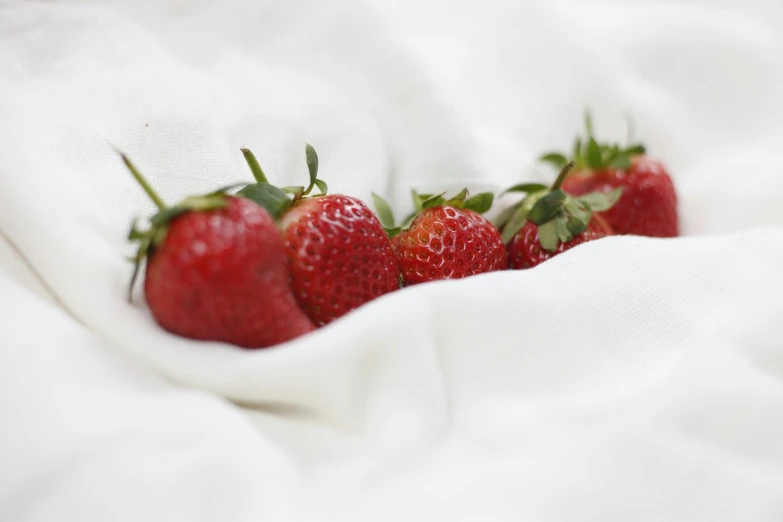 some fresh strawberries on a white blanket, close up
