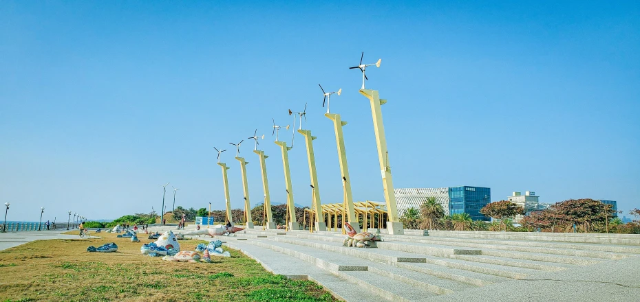 there are several people sitting under a row of giant poles