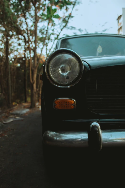 a old black car parked on the side of a road