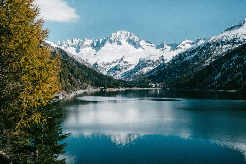 the mountain range is reflected in the still calm water