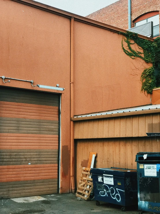 the back side of an orange building with a garage