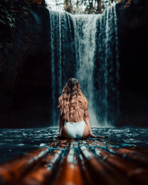 a woman sitting on top of a wooden dock