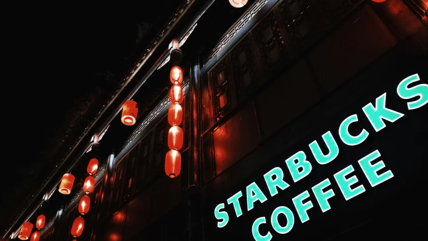 a group of red lights hanging over the top of a starbucks