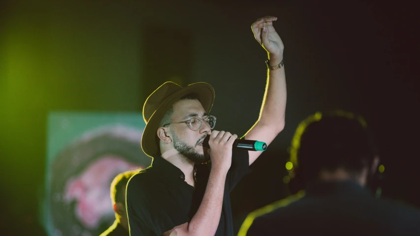 a man standing at a microphone holding a microphone in his hand