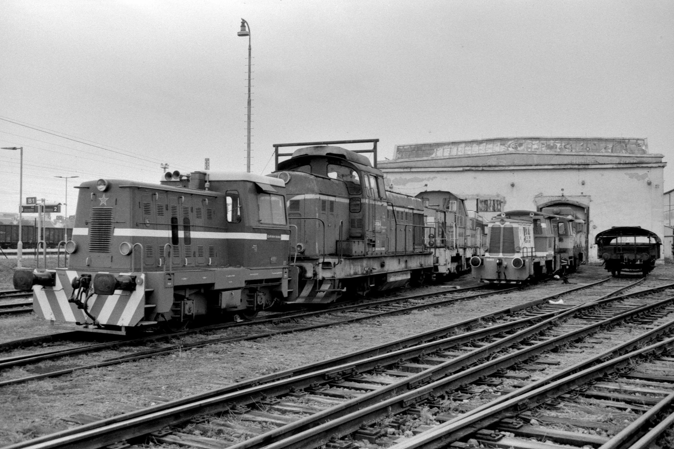 a group of trains sitting next to each other on train tracks