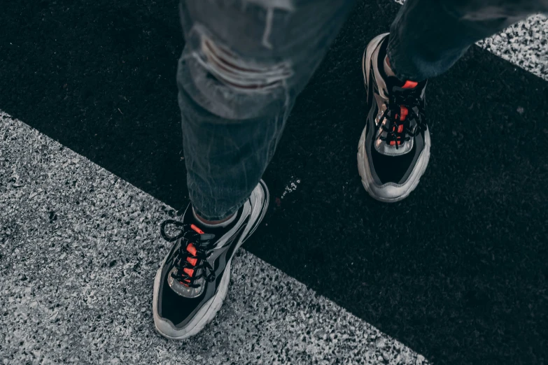 person wearing black sneakers standing on the street