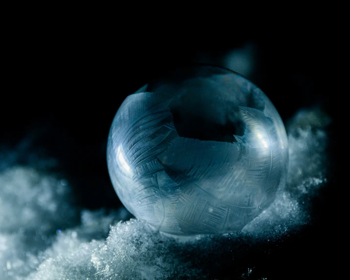 a marble ball sitting on top of snow