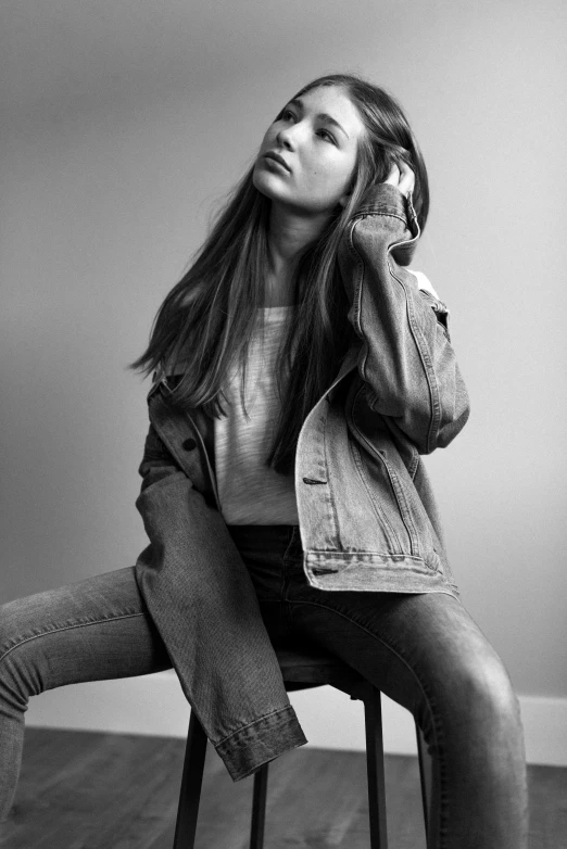 a woman sitting on a stool and talking on the phone