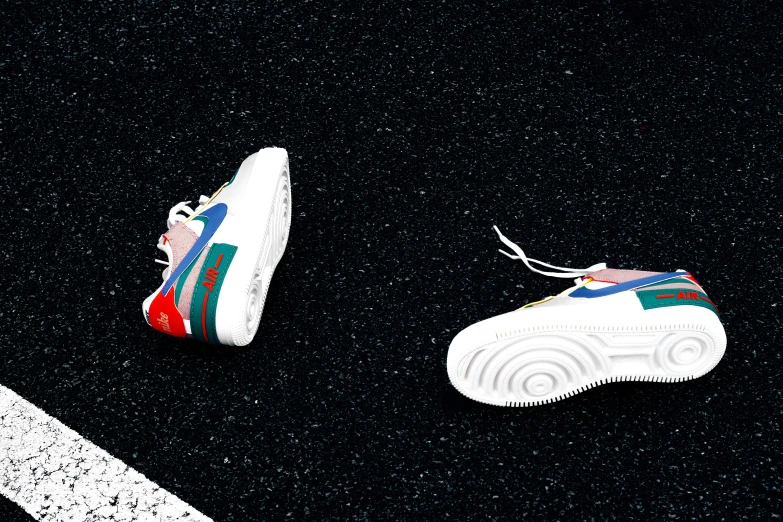 two pairs of colorful sneakers sit on the ground