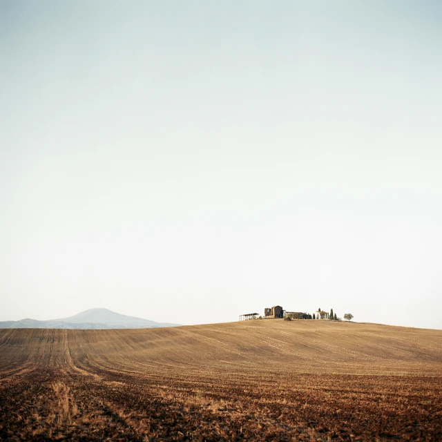 a small hill with a single house in the middle of it