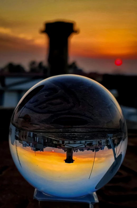 a sphere shaped sculpture sitting on top of a sidewalk