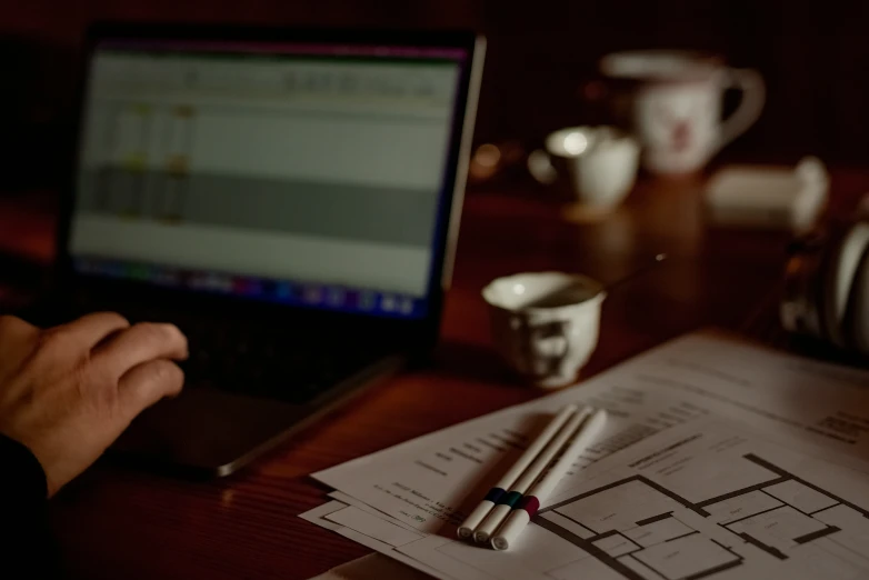 a desk with a cup and some papers on it