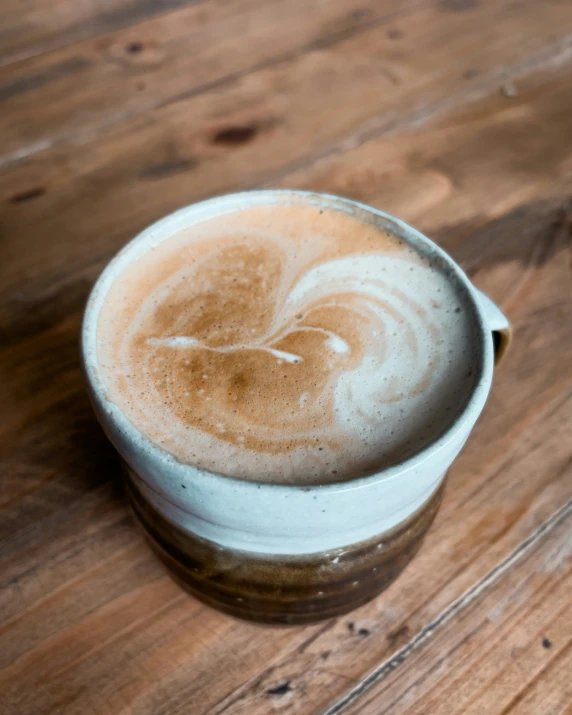 there is a cup of liquid on the wooden surface