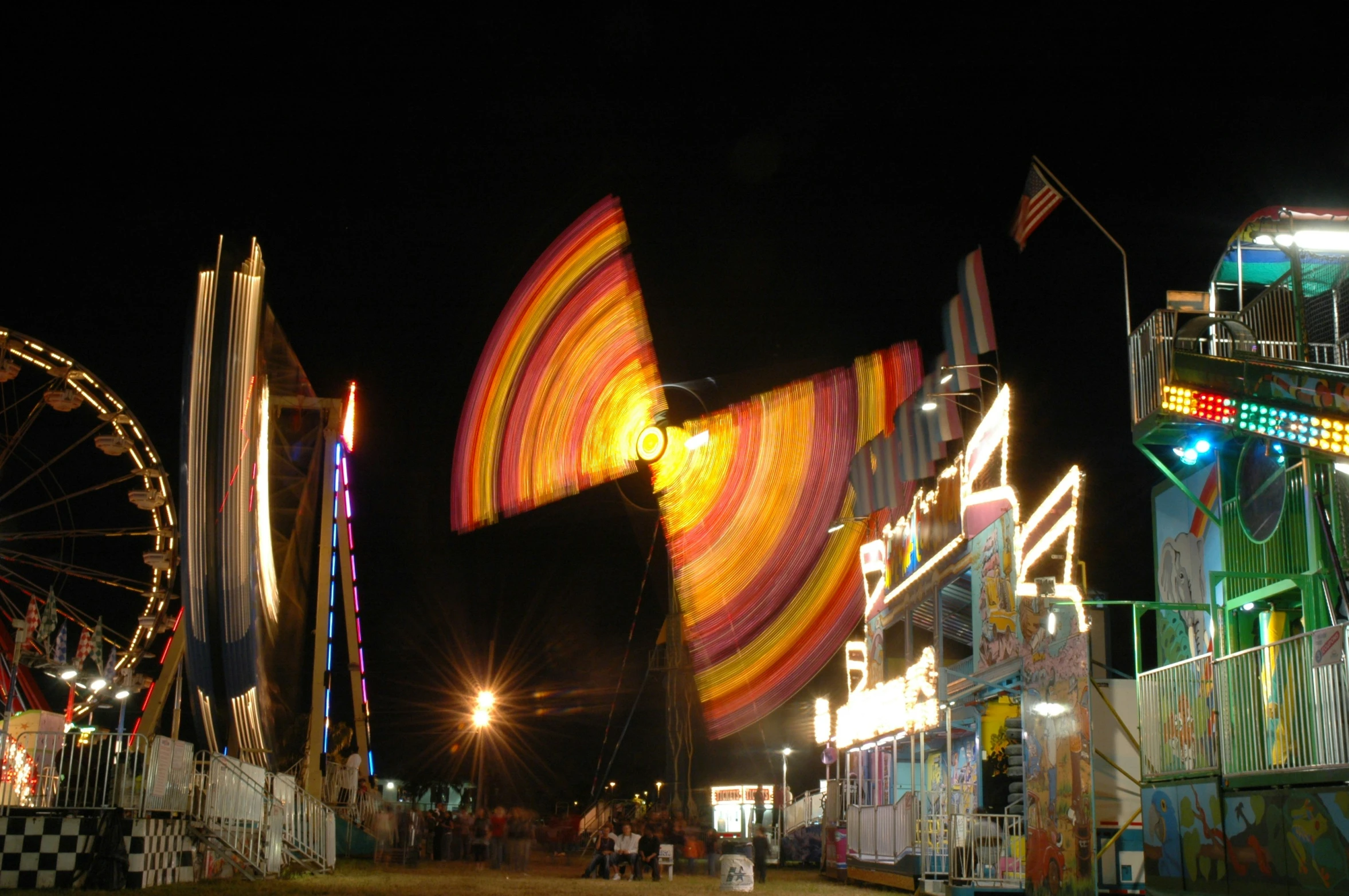 there are carnival rides at night and a ferris wheel