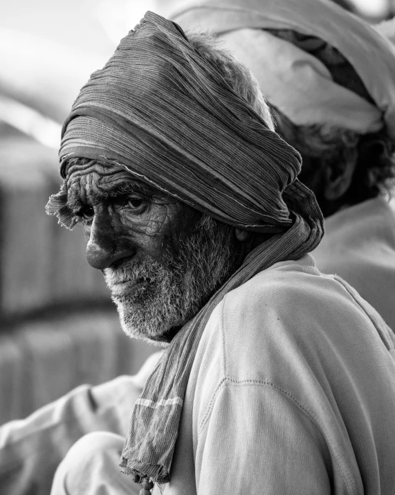 a man wearing a turban standing next to another man