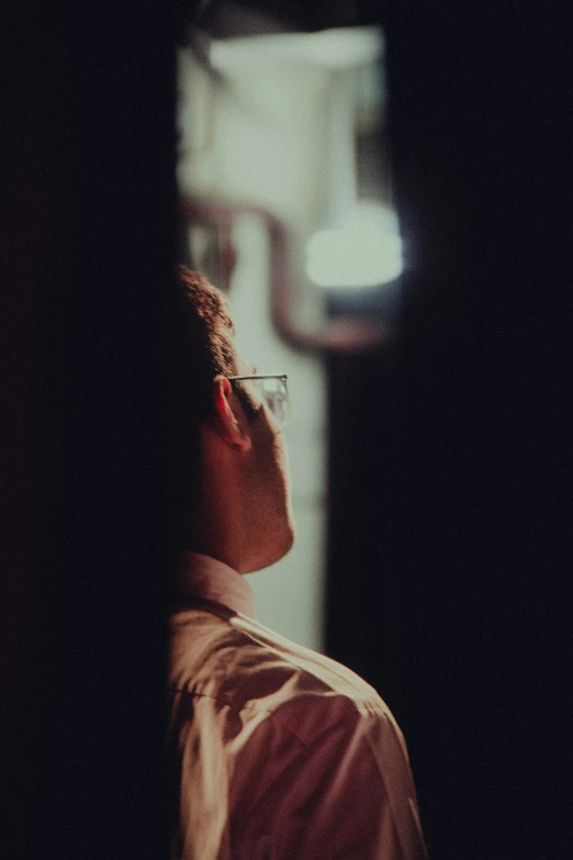 a person with glasses looking into the light