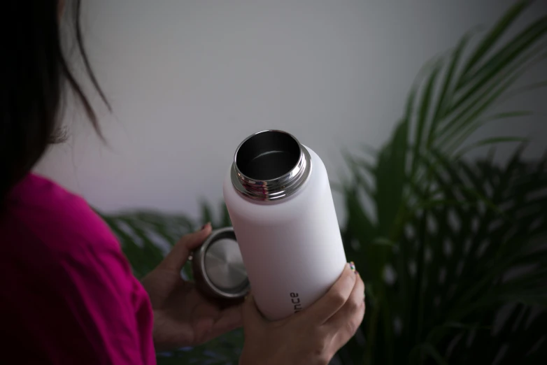 a person holding a water bottle with their hands