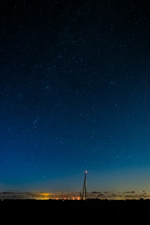 stars shine over a skyline with a radio tower