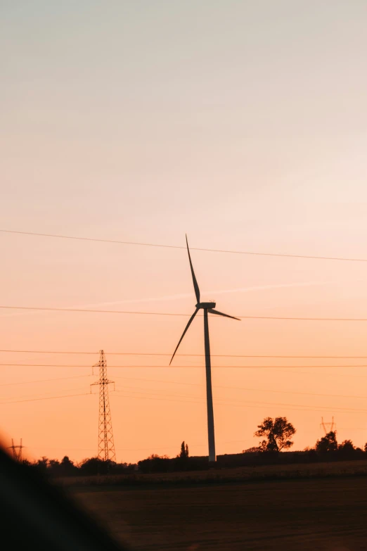 a windmill near an electrical tower and other power lines