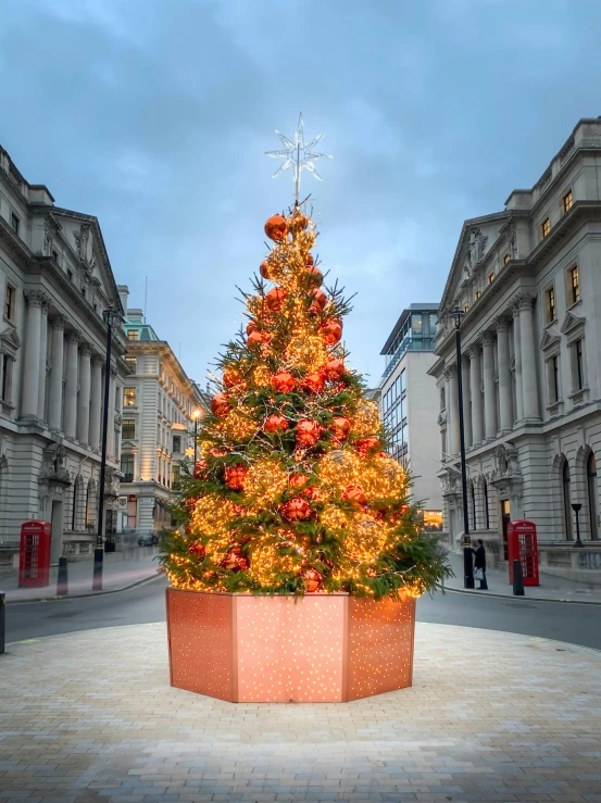 a very large christmas tree sitting in the middle of a square