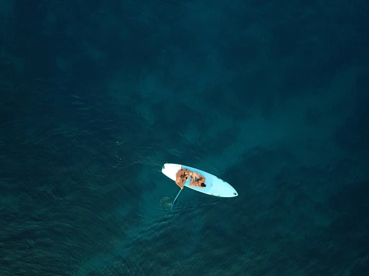 a man riding on top of a white surfboard in the ocean