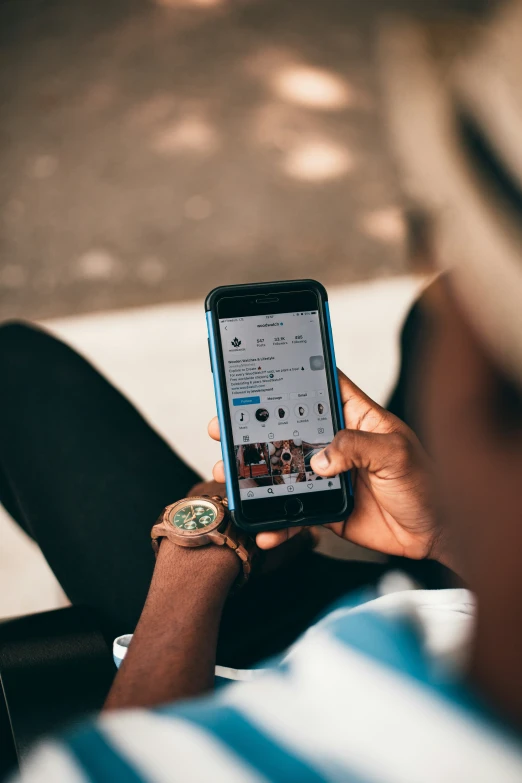 someone looking at their phone while sitting on the ground