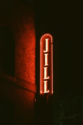 the neon sign in front of a dark red building