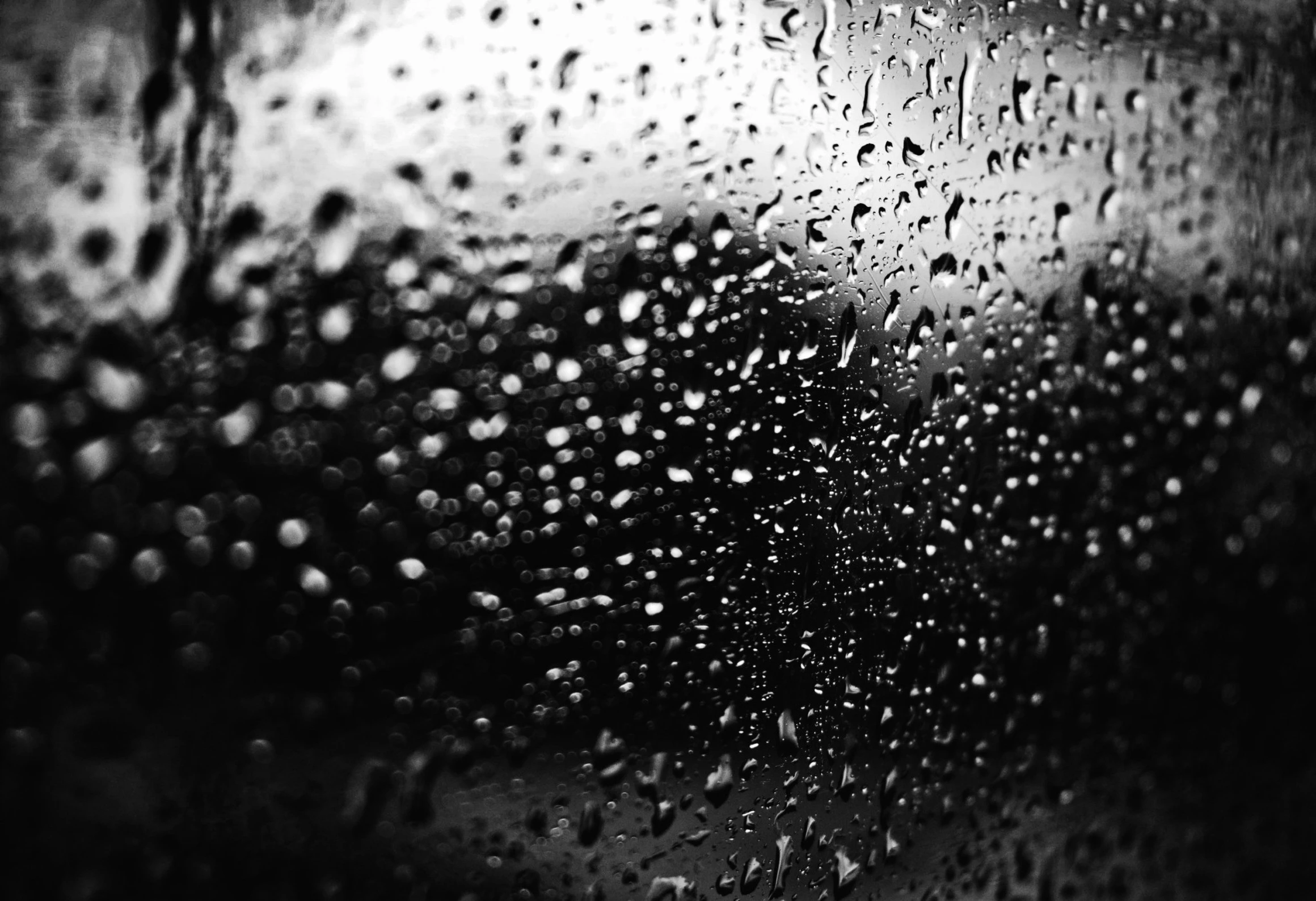 a black and white pograph of raindrops on a window