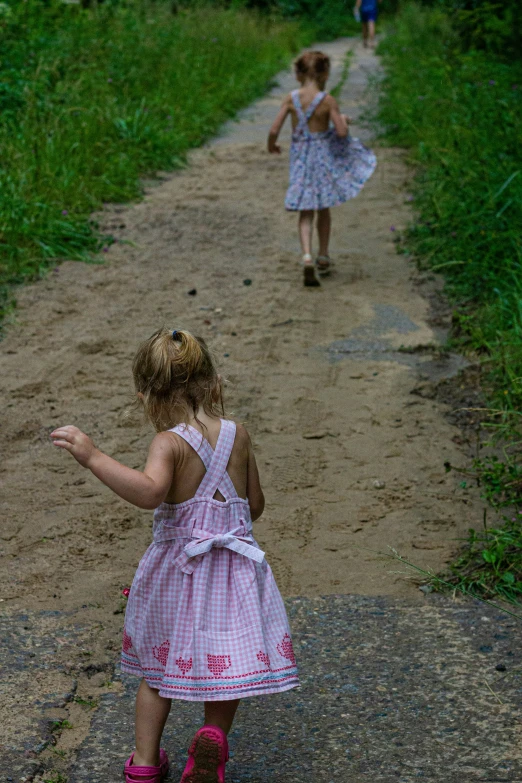 the two girls are walking on the path