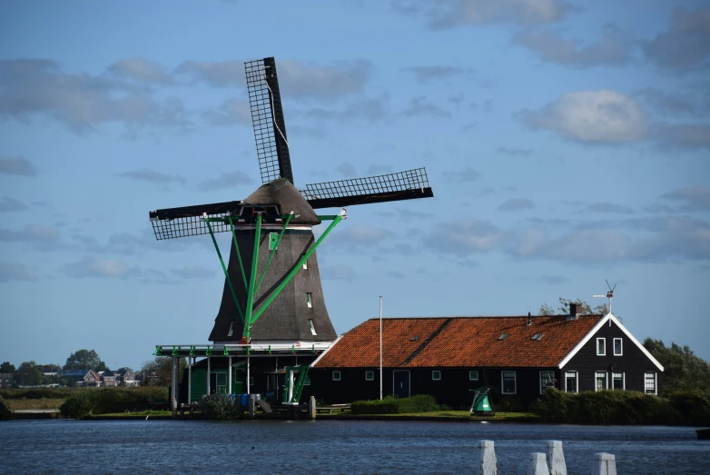 a windmill with an iron roof on the water