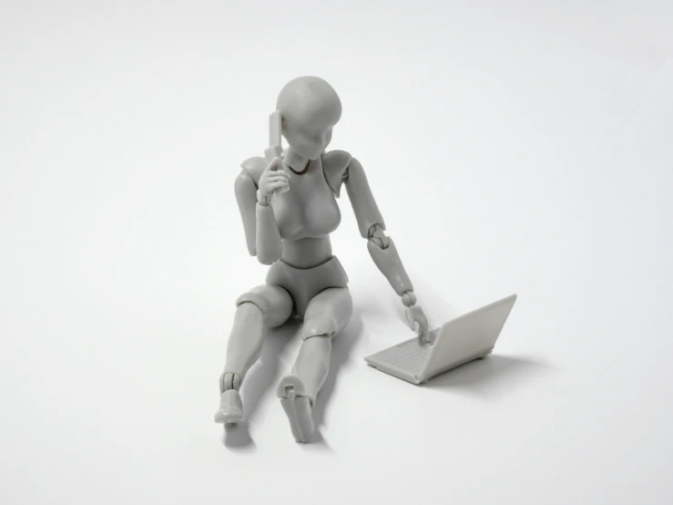 a white, robot - like figure uses a laptop computer