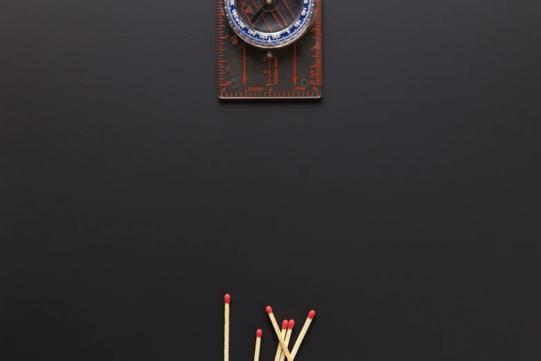 matches on a black surface with a clock above