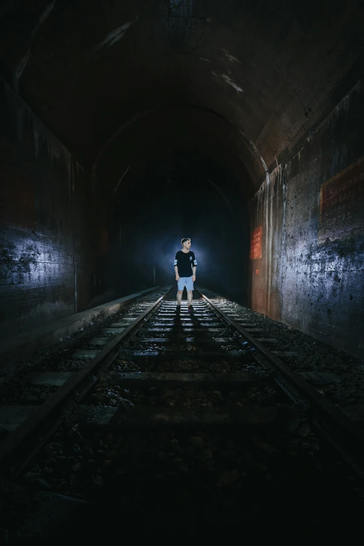 a man walking alone in a dark tunnel