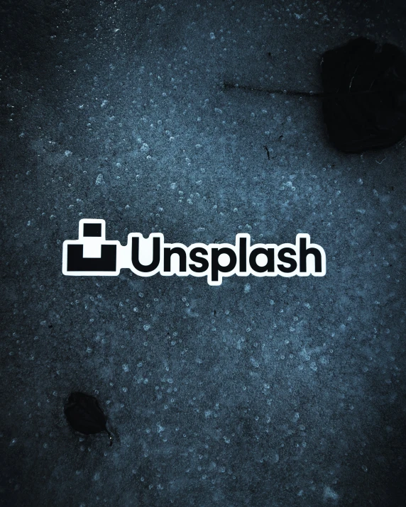 the unsplash logo is shown on the pavement
