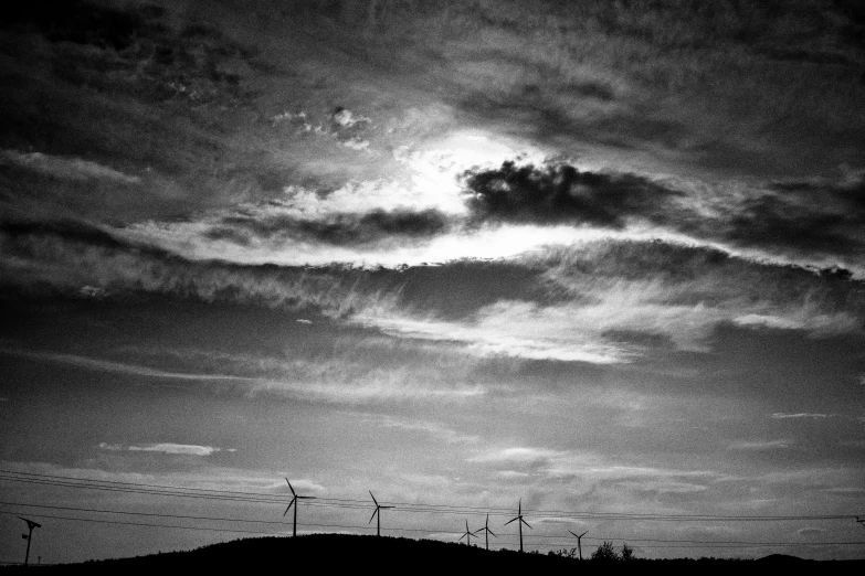 dark clouds hang from the horizon behind power lines