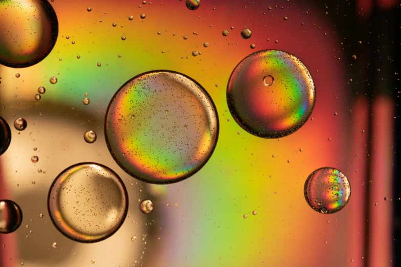 a group of bubbles that are on a rainbow colored surface