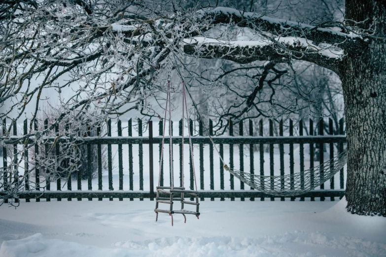 an empty chair hanging off of a metal fence