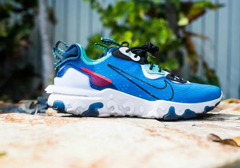 the nike react react is painted blue with red, green and white accents