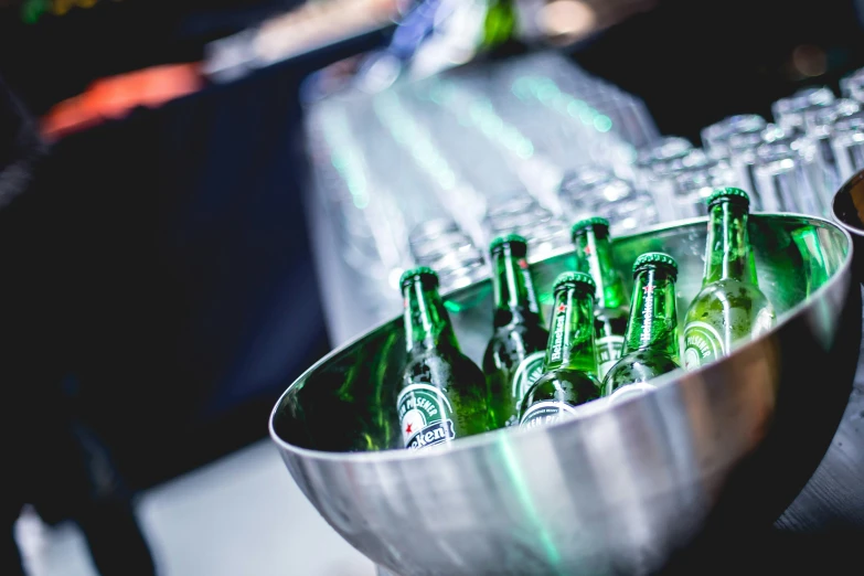 empty plastic glasses sit in an ice bucket with beer bottles in it