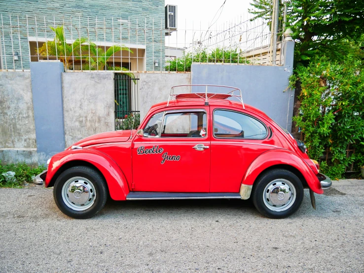 a red car is parked next to a building