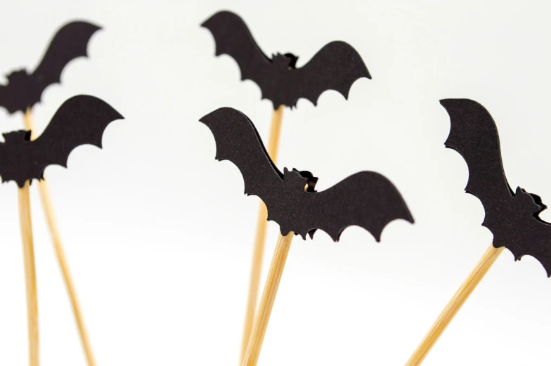 a group of black bats sticks sitting on top of cake