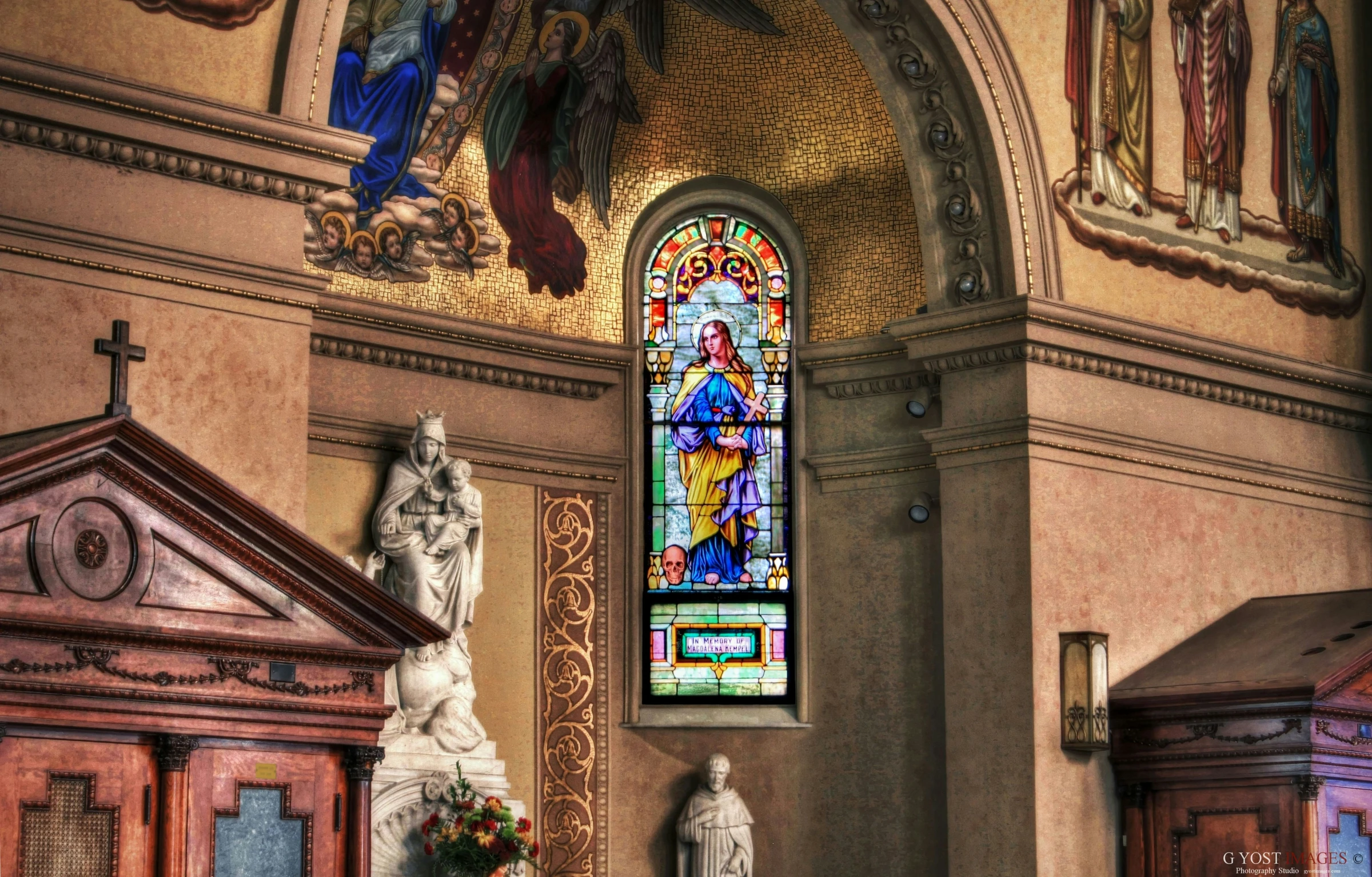 a church with a statue in the middle and colorful stained glass window