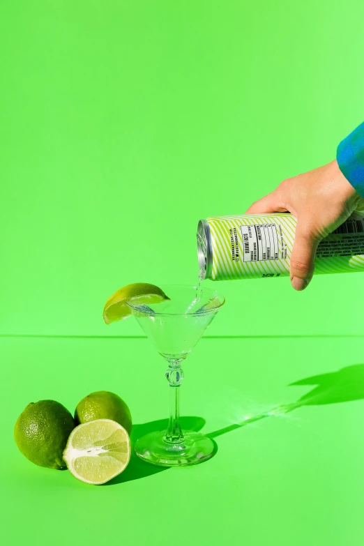 a person pouring lemon juice into a margarita glass