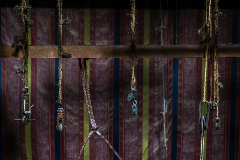 a colorful wall with ropes hanging from the ceiling