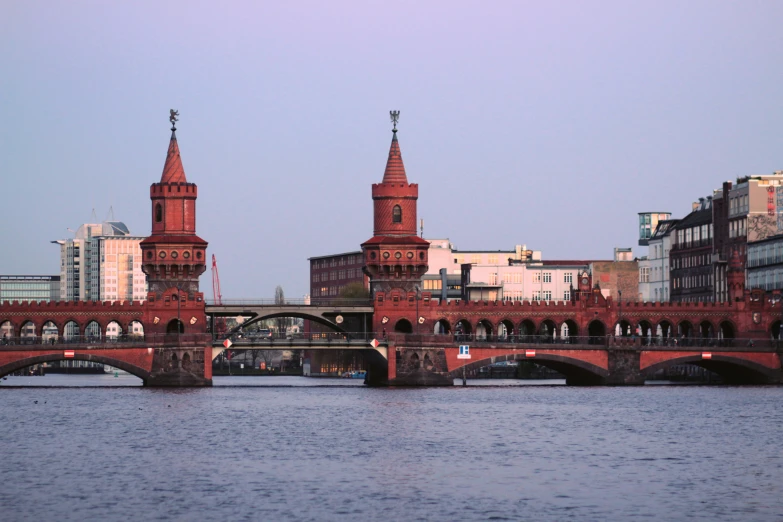 some bridge towers by the water and buildings