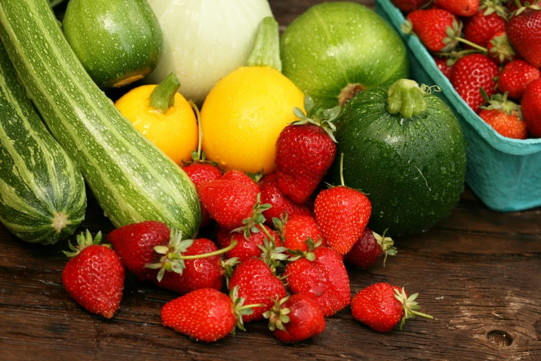 several different fruits and vegetables are on a wooden table