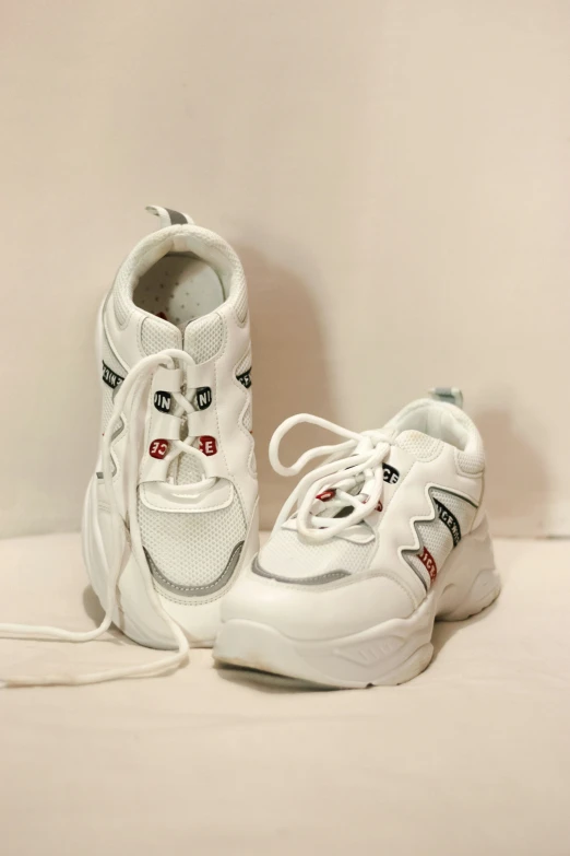 a pair of white shoes sitting on top of a bed