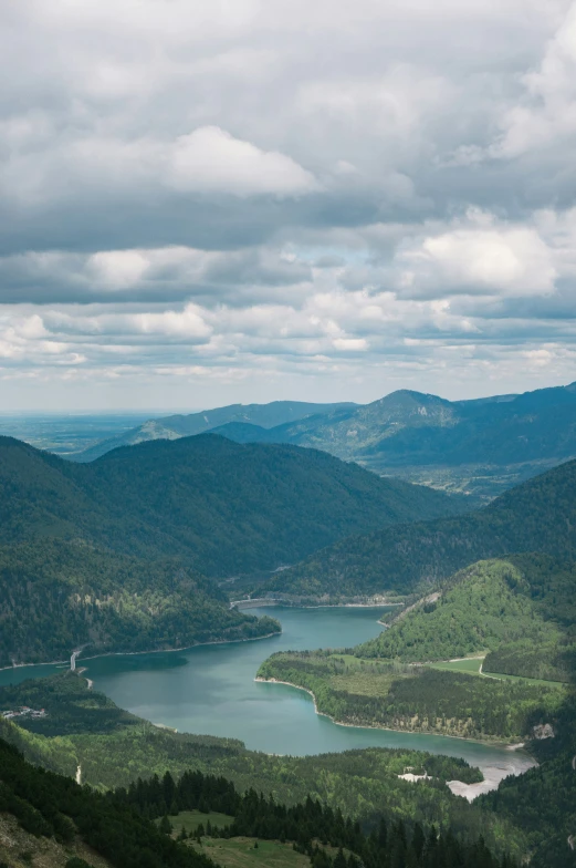 an aerial view of some green mountains and lake