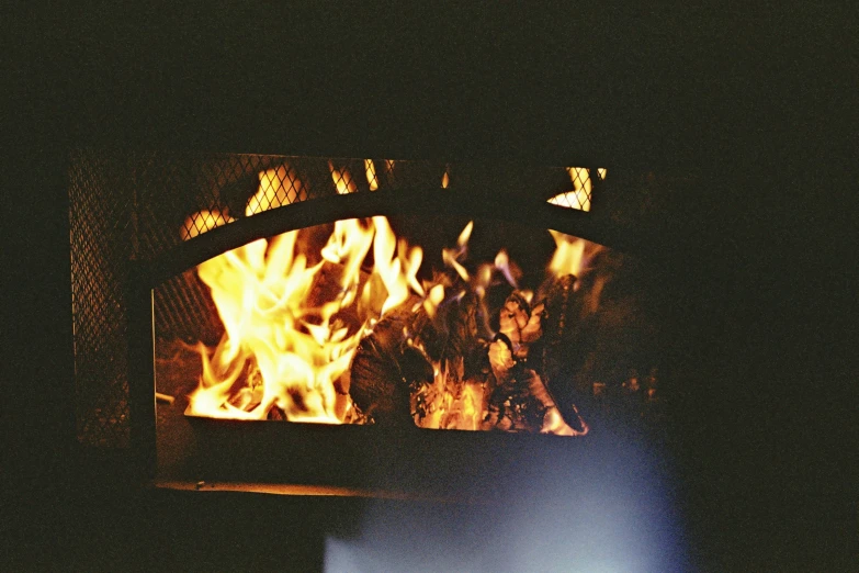 a wood burning oven with flames in the fireplace
